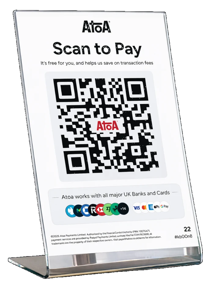 An acrylic Atoa Scan to Pay stand on a counter, its QR code above a line reading that Atoa works with all major UK banks and cards